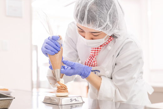 織田製菓専門学校の製菓実習でホイップを絞る学生