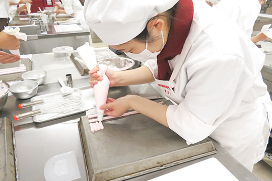 絞り袋を扱う織田製菓専門学校製菓学科製菓コースの学生