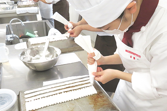 絞り作業をする織田製菓専門学校製菓学科製菓コースの学生