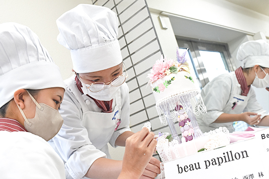 仕上げ作業に取り組む織田製菓専門学校製菓学科製菓コースの学生