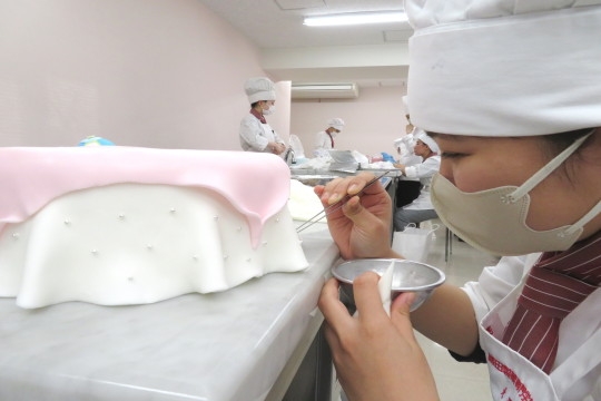 シュガークラフトの模様を描く織田製菓専門学校製菓学科製菓コースの学生たち