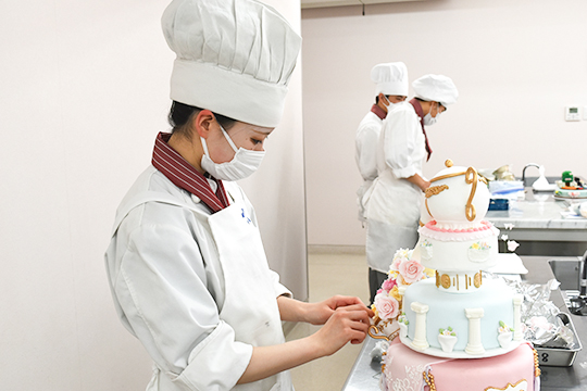 ケーキを組み上げる織田製菓専門学校製菓学科製菓コースの学生たち