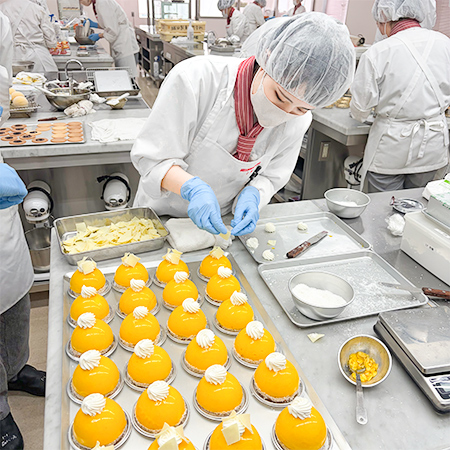 マンゴーとココナッツのムースを製造する織田製菓専門学校の学生